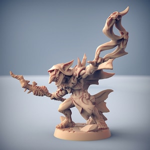 Könnte beinhalten: Eine detaillierte Miniaturfigur eines Goblins, in hellbrauner Farbe bemalt. Der Goblin hält einen Stab mit einem Schädel an der Spitze und trägt einen Umhang mit einem Schädelmuster. Der Goblin steht auf einem Sockel mit einer steinartigen Textur.