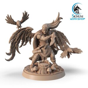 Op de afbeelding: Een miniatuurfiguur van een gevleugelde elfenkrijger met golvend haar, die een dolk vasthoudt en op een boomstronksockel staat. Twee raven zitten op de uitgespreide vleugels van de elf. Het figuur is geschilderd in een lichtbruine kleur.