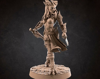 May include: A detailed miniature figurine of a female warrior with horns, wearing armor and holding a dagger. The figurine is painted in a light brown color and stands on a circular base.
