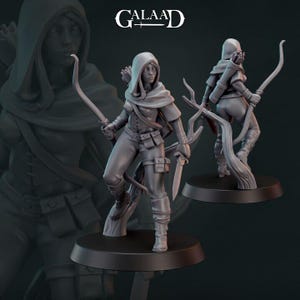 Può includere: Una statuetta in miniatura di plastica grigia di un'arciera femminile con arco e freccia. La figura indossa un mantello con cappuccio e un'armatura di cuoio. La figura è in piedi su una base rotonda.