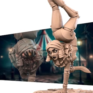 May include: A painted figurine of a female clown in a handstand pose. The clown is wearing a ruffled collar and has a knife in one hand. The figurine is painted in a light brown color and has a detailed face with dark eyes and a painted smile.