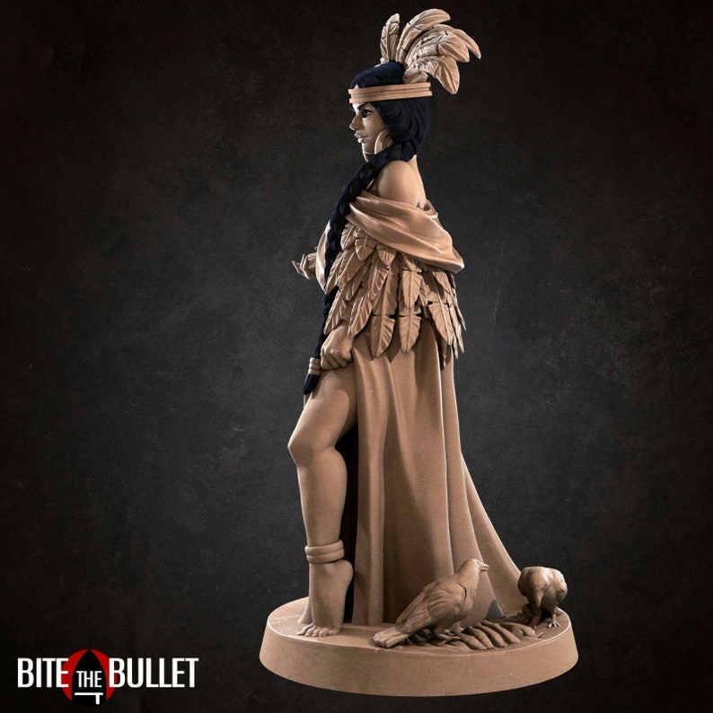 May include: A detailed figurine of a woman wearing a feathered headdress and a long robe. She is standing with her right leg slightly bent and her left leg straight. She is holding a small object in her right hand. Two birds are at her feet.