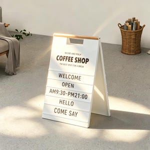 May include: A white A-frame sidewalk sign with a wooden handle at the top. The sign features black text reading BEORE AND RSILY COFFEE SHOP, THE BEST SPOT FOR A BREW, WELCOME, OPEN, AM9:30-PM21:00, HELLO, and COME SAY on horizontal slats.