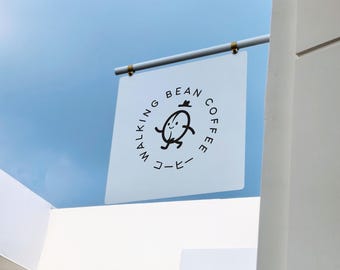May include: A square, semi-translucent white hanging sign featuring a black graphic of a cartoon coffee bean with arms and legs, wearing a small hat. The text "WALKING BEAN COFFEE" and the Japanese characters "コーヒー" are printed in black.