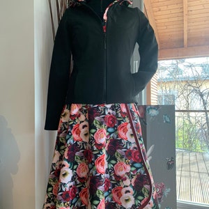 Puede incluir: Una chaqueta negra con forro de estampado floral y una falda floral a juego. La falda tiene un ribete burdeos.