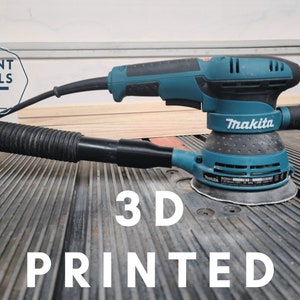 May include: A blue Makita random orbital sander with a dust collection hose attached. The sander is sitting on a gray textured surface with the words "3D PRINTED" in white letters.