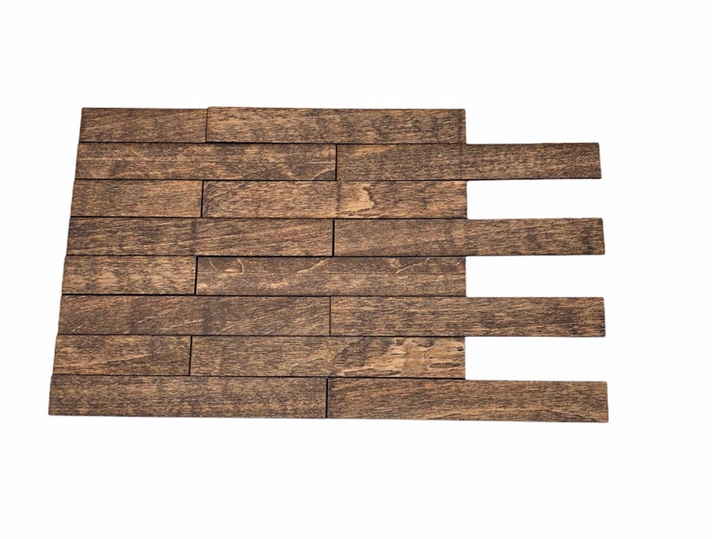 May include: A section of wooden planks arranged in a staggered pattern, creating a rustic, textured surface. The planks are a warm brown color with visible wood grain, suggesting a natural, aged appearance. The arrangement is against a white background.