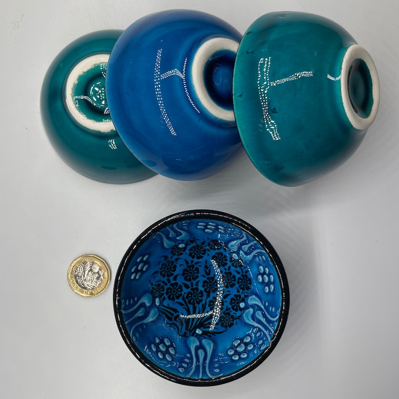 Puede incluir: Tres cuencos de cer&aacute;mica azul y verde con dise&ntilde;os blancos. Los cuencos est&aacute;n apilados uno encima del otro. El cuenco de abajo tiene un dise&ntilde;o floral. Los cuencos tienen un di&aacute;metro de aproximadamente 10 cm.