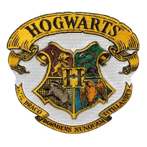 Könnte beinhalten: Gestickter Aufnäher mit dem Wappen von Hogwarts. Das Wappen ist in vier Abschnitte unterteilt, die jeweils ein Hogwarts-Haus repräsentieren. Der Aufnäher trägt die Worte "HOGWARTS" und "DRACO DORMENS NUNQUAM TITILLANDUS" in Gold.