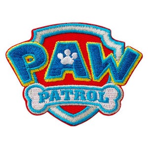 Könnte beinhalten: Ein gestickter Aufnäher in Rot, Weiß und Blau mit den Worten "PAW PATROL" und einem Pfotenabdruck in der Mitte.
