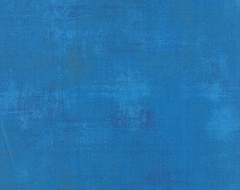 May include: A solid blue fabric with a textured appearance. The color is a vibrant shade of blue, with subtle variations in tone across the surface. The fabric has a slightly distressed look, with visible brushstrokes or markings.