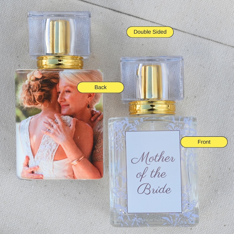 May include: Double-sided perfume bottle with a gold cap. The front side has a white label with the text "Mother of the Bride" in purple script. The back side has a photo of two women hugging.