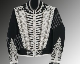 Könnte beinhalten: Schwarze Jacke mit weißer Zierleiste und silberfarbenen Knöpfen. Die Jacke hat aufwendige weiße Stickereien auf der Vorderseite, den Manschetten und den Schultern. Die Jacke hat einen hohen Kragen und eine Reihe von Knöpfen auf der Vorderseite.