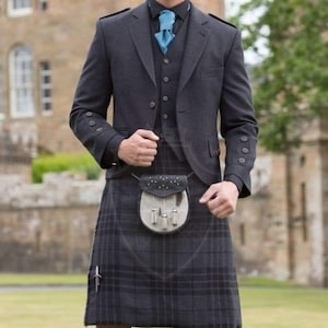 May include: A formal grey suit with a matching waistcoat and kilt. The kilt is a dark grey plaid pattern. A black shirt and light blue tie are worn under the suit jacket. A small leather sporran hangs from the waist.