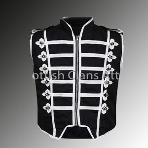 Peut inclure: Gilet noir avec des détails blancs, un col montant et une fermeture éclair. Le gilet présente des rayures horizontales blanches et des ornements floraux. Le texte "Scottish Clans Att" est visible.