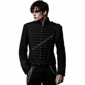May include: A black military-style jacket featuring a high collar, intricate braided cord detailing, and rows of round buttons across the front. The sleeves and hem are adorned with embroidered patterns, and the text SCOTTISH CLANS ATTIRE is visible.