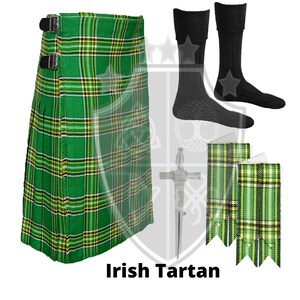 K&ouml;nnte beinhalten: Ein gr&uuml;ner, gelber und schwarzer karierter Kilt mit schwarzen Schnallen. Der Kilt wird von einem Paar schwarzen Socken, zwei gr&uuml;n-gelben karierten Sch&auml;rpen und einer silbernen Kiltnadel begleitet.