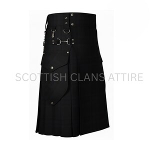 Op de afbeelding: Zwarte kilt met plooien, zakken en metalen hardware. De kilt heeft een hoge tailleband met decoratieve gespen en riemen. De tekst "SCOTTISH CLANS ATTIRE" staat onderaan de afbeelding.