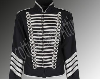 Könnte beinhalten: Eine schwarze Jacke mit silbernen Verzierungen und Knöpfen. Die Jacke hat einen Stehkragen und lange Ärmel. Die Ärmel haben silberne Streifen.