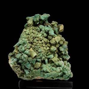 May include: A cluster of green and light green crystals with a rough, textured surface. The crystals are arranged in a dense, irregular formation.