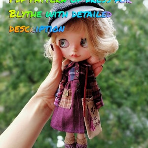 Peut inclure: Un patron PDF pour une robe pour une poupée Blythe. La poupée porte une robe violette avec une chemise à carreaux par-dessus, un chapeau marron et des bottes marron. La poupée tient un petit sac marron avec le texte "You Ride" brodé dessus.