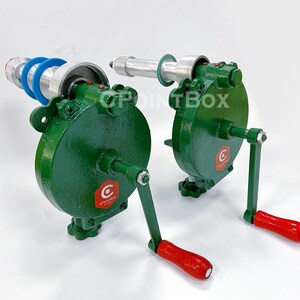 May include: Two green hand crank machines with red handles. The machines have a silver metal roller and a blue plastic ring. The machines are labeled "C" with a red hexagon.