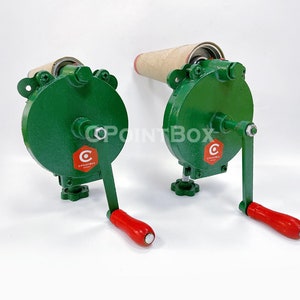 May include: Two green manual paper roll holders with red handles. Each holder has a cardboard roll and a crank to wind the roll. The holders have a red logo with the text "C POINTBOX".