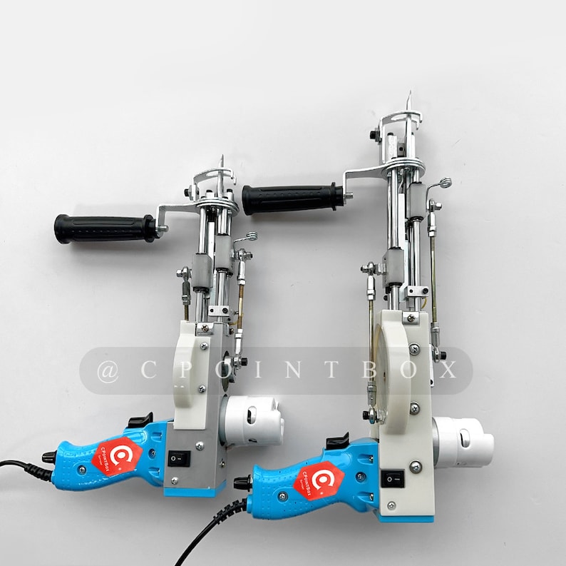 May include: Two blue and white electric fabric cutters with black handles. The cutters have a silver metal mechanism and a black power cord. The text "@CPOINTBOX" is visible on the white background.