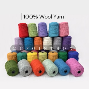 Puede incluir: Una colección de 24 ovillos de hilo de lana 100% en varios colores, incluyendo rojo, verde, morado, azul, rosa, amarillo, naranja y gris. El hilo está dispuesto en forma de pirámide, con los ovillos en la parte superior de la pirámide siendo los más grandes y los ovillos en la parte inferior siendo los más pequeños. El hilo está etiquetado como "100% lana" y "@CPOINTBOX".