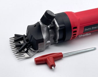 May include: Red electric sheep shearer with a black handle and a silver blade. The shearer is on a white surface with a red and silver screwdriver.