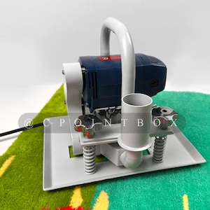 May include: A white and blue electric sander with a handle and a white base. The sander is sitting on a green and yellow rug.