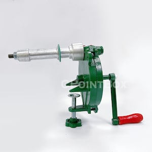 May include: A green metal hand crank food grinder with a silver metal crank arm and a red handle. The grinder has a clamp to attach it to a surface.