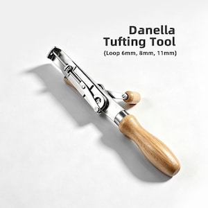May include: A Danella Tufting Tool with a silver metal body and a light brown wooden handle. The tool features a mechanical arm and includes text stating Danella Tufting Tool (Loop 6mm, 8mm, 11mm) to indicate the adjustable loop height settings.