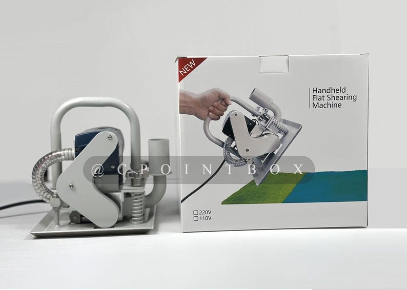 May include: A handheld flat shearing machine with a gray and silver body. The machine has a black cord and a clear hose. The machine is on a white surface. The box for the machine is white with the text "Handheld Flat Shearing Machine" and "NEW" printed on it. The box also has the text "120V" and "110V" printed on it.