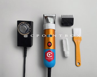 May include: A blue and gold electric hair clipper with a silver blade, a black control box with a dial, a white brush, a clear bottle of oil, and a black comb attachment. The clipper has a red button and the text "CPOINTBOX" on the side.