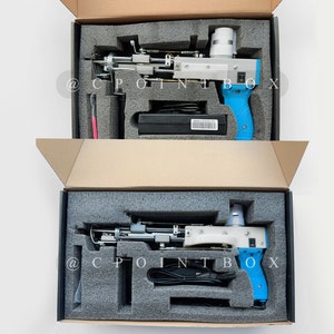 May include: Two blue and white handheld tools with black cords in open cardboard boxes with gray foam inserts. The tools have a black power switch and a black trigger. The boxes have the text "@CPOINTBOX" printed on them.