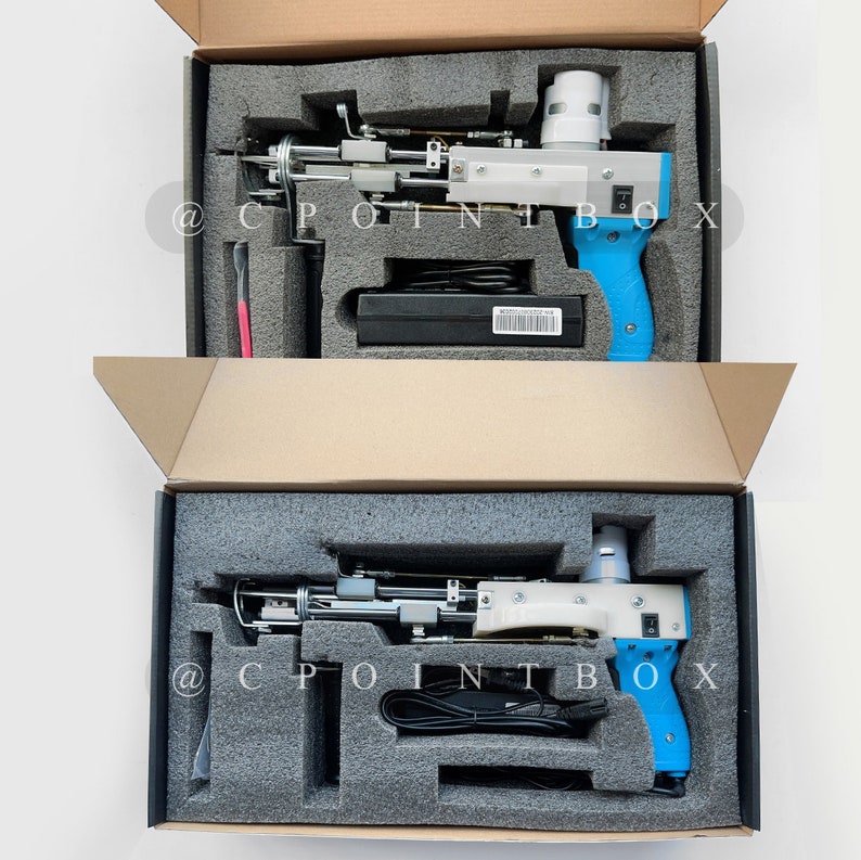 May include: Two blue and white handheld tools with black cords in open cardboard boxes with gray foam inserts. The tools have a black power switch and a black trigger. The boxes have the text "@CPOINTBOX" printed on them.