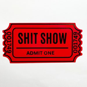 May include: A red ticket with black text that reads "SHIT SHOW" and "ADMIT ONE". The ticket has a serrated edge and the numbers "001749" are printed on the left and right sides.