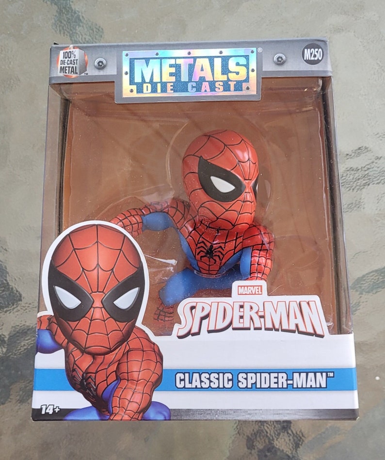 May include: A red and blue die-cast metal figurine of Spider-Man in a classic pose. The figurine is packaged in a box with the words "Metals Die-Cast" and "Spider-Man Classic Spider-Man" printed on it.