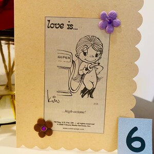 May include: A cartoon illustration of a couple at a gas station pump. The woman is filling the car with gas. The caption reads "love is... high-octane!" and is from the comic strip "Love is..." by Kim.