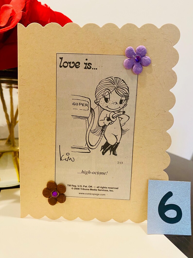 May include: A cartoon illustration of a couple at a gas station pump. The woman is filling the car with gas. The caption reads "love is... high-octane!" and is from the comic strip "Love is..." by Kim.