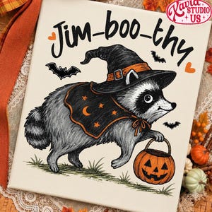 Puede incluir: Un lienzo rectangular con una ilustración en blanco y negro de un mapache con sombrero de bruja y una capa con estrellas naranjas y una luna creciente. El mapache sostiene un cubo de calabaza naranja. El texto dice Jim-boo-thy.