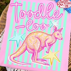 May include: Pink graphic tee with a kangaroo illustration and the words "Toodle-loo" in white script. The design includes teal and yellow stars and vertical stripes. A Kavia Studio US logo is in the upper right corner.