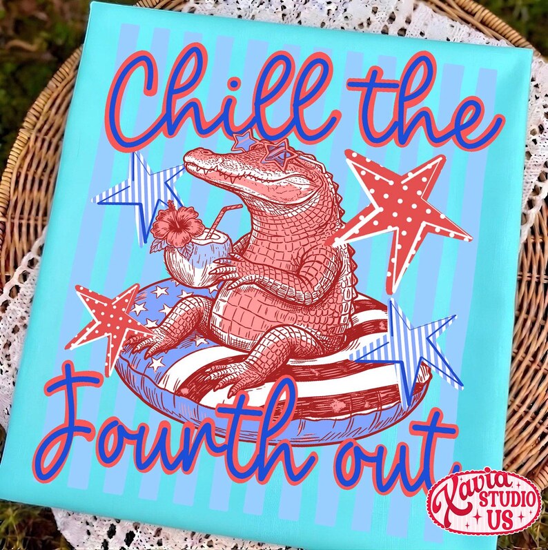 May include: A light blue graphic tee with the text "Chill the Fourth out." The design features a red alligator wearing star-shaped sunglasses, relaxing on a patriotic floatie, with red and blue stars.