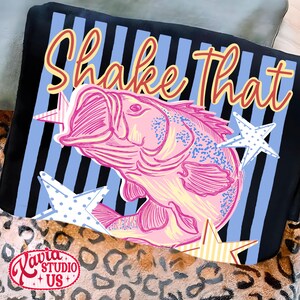 May include: A black throw pillow with a pink fish illustration and the words "Shake That" in a script font. The background has blue and black stripes with star accents. The pillow has a leopard print border.