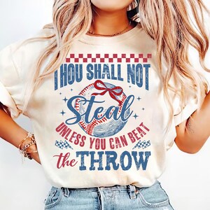 May include: A white t-shirt with a vintage baseball graphic and the text "Thou Shall Not Steal Unless You Can Beat The Throw".