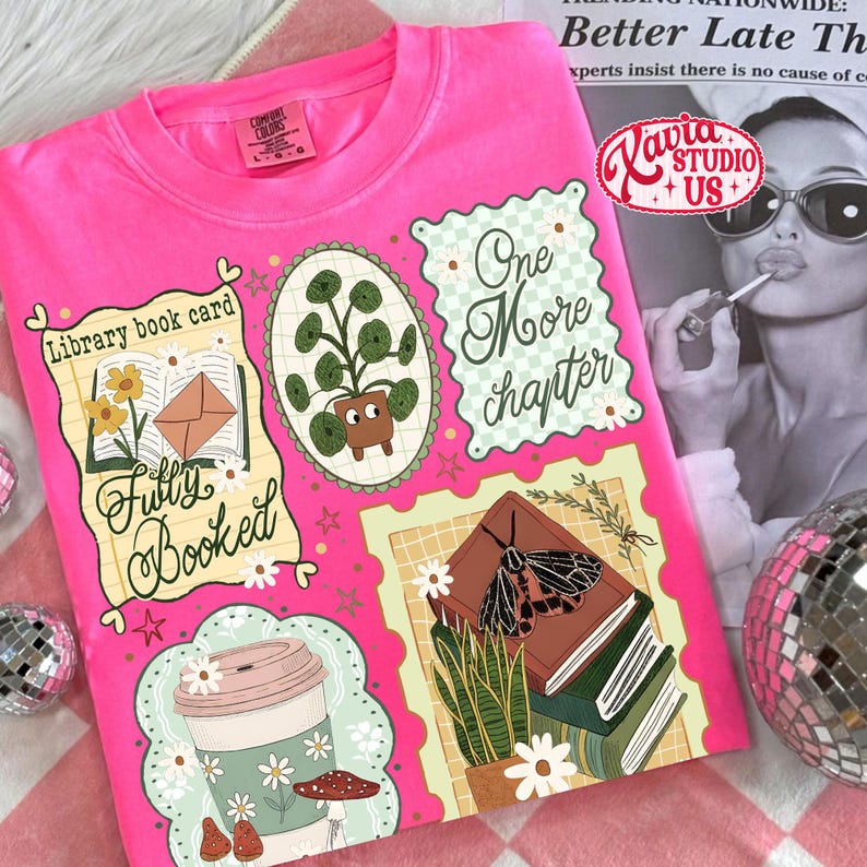 May include: A hot pink Comfort Colors t-shirt featuring a collage of book-themed illustrations. The design includes a coffee cup, potted plant, and the text "Fully Booked" and "One More Chapter". The shirt also has the logo "Kavia Studio US+".