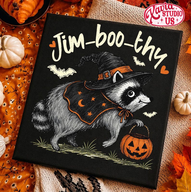 May include: A square black canvas print featuring a gray raccoon wearing a black witch hat and a black cape with orange stars and a crescent moon. The raccoon holds an orange jack-o'-lantern bucket. The text Jim-boo-thy is printed in white.