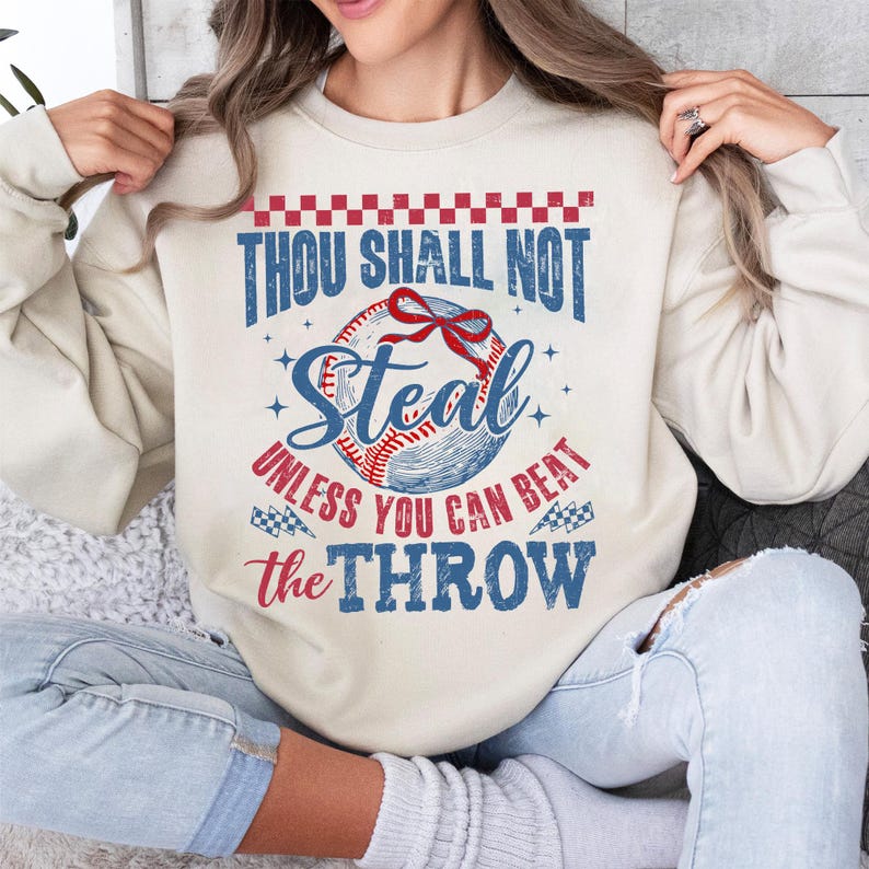 May include: A cream colored sweatshirt with a baseball graphic and the text "Thou Shall Not Steal Unless You Can Beat The Throw".