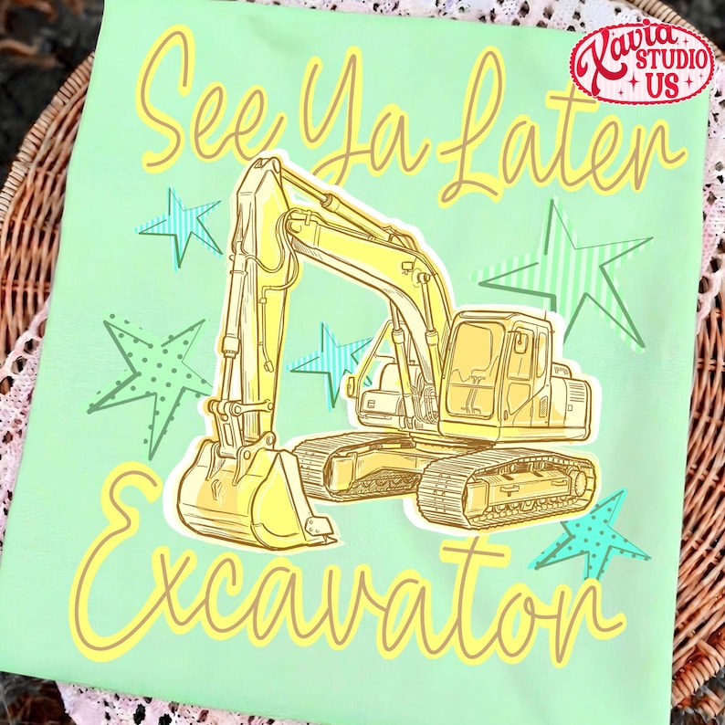 Pu&ograve; includere: Maglietta verde chiaro con un'illustrazione di escavatore giallo e la scritta "See Ya Later Excavator". Il design include stelle gialle e blu e un logo nell'angolo in alto a destra.